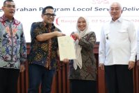 Sekda Tanah Bumbu Yulian Herawati menerima sertipikat aset Barang Milik Daerah (BMD) dalam rangkaian kunjungan kerja Komisi II DPR RI di Gedung KH. Idham Chalid, Banjarbaru, Rabu (2/9/2026).