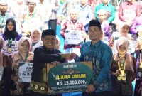 Wakil Bupati Tanah Laut, H. M. Zazuli, saat menyerahkan hadiah umroh kepada juara umum ajang MTQN XLVIII Tanah Laut | Foto : Diskominfostasan Tala