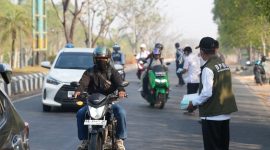Petugas BPBD dan Dinas Kesehatan Tanah Bumbu membagikan masker gratis kepada masyarakat dan pengguna jalan sebagai langkah antisipasi dampak kabut asap karhutla.
