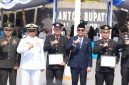 Bupati Tanah Bumbu Andi Rudi Latif menyerahkan penghargaan kepada Kasat Resnarkoba Polres Tanah Bumbu AKP Anang Setyawan dan Banit 1 Satresnarkoba Aipda Hendra Gunawan dalam rangkaian Upacara Hari Kesaktian Pancasila 2026, Kamis (1/10/2026).