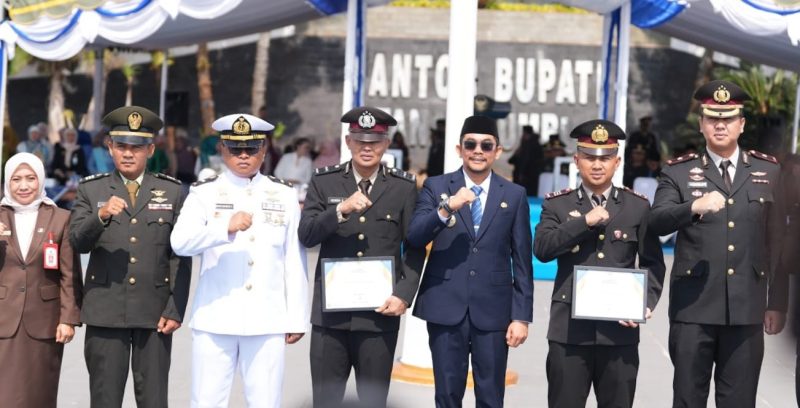Bupati Tanah Bumbu Andi Rudi Latif menyerahkan penghargaan kepada Kasat Resnarkoba Polres Tanah Bumbu AKP Anang Setyawan dan Banit 1 Satresnarkoba Aipda Hendra Gunawan dalam rangkaian Upacara Hari Kesaktian Pancasila 2026, Kamis (1/10/2026).